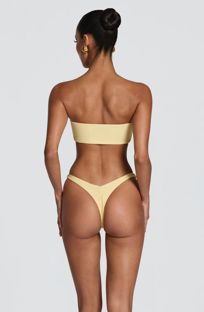 Braga de bikini amarilla limón con abertura en la espalda y laterales finos, tiro medio
