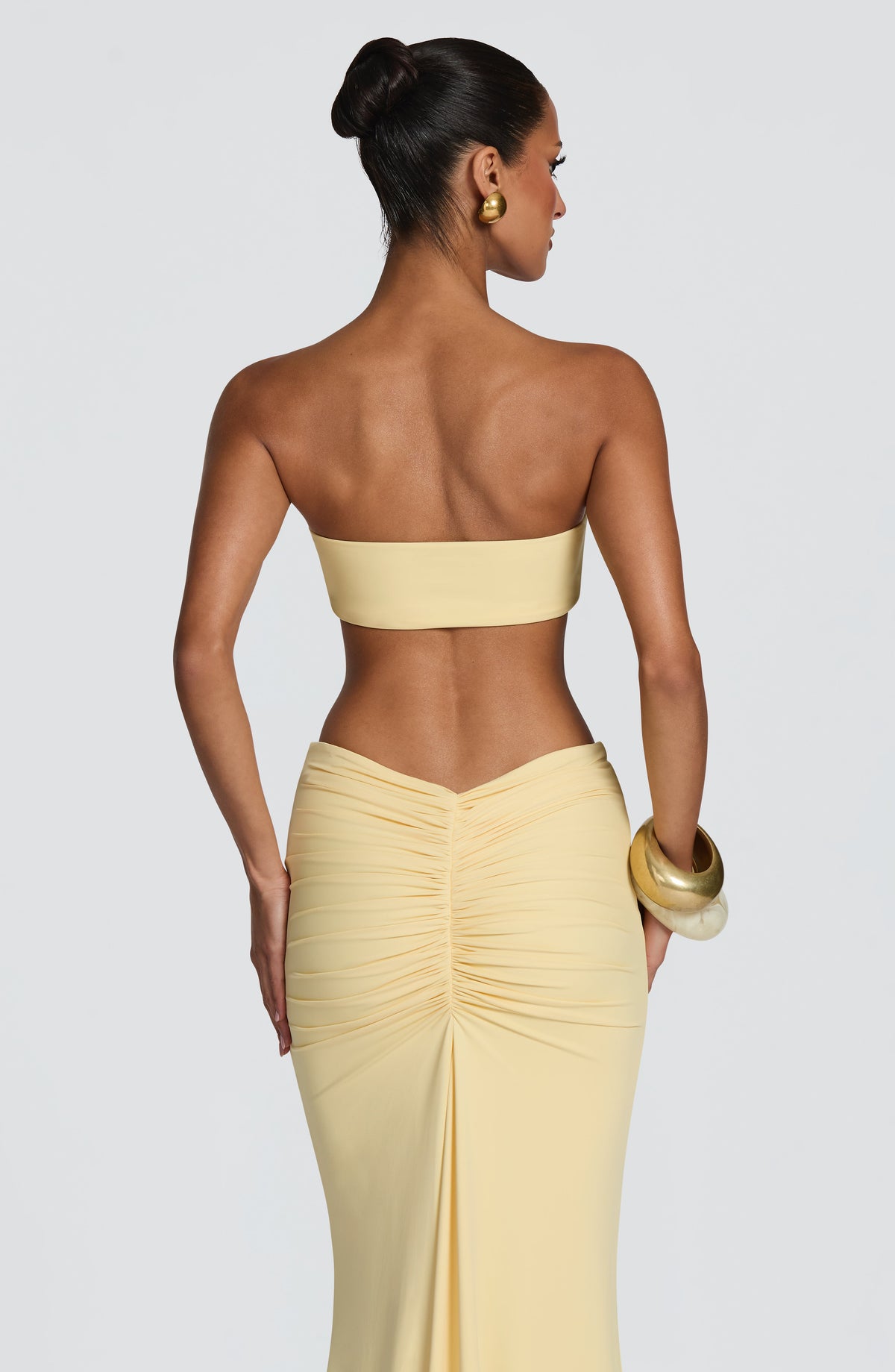 Top de bikini bandeau amarillo limón con espalda lisa y adorno dorado frontal al centro