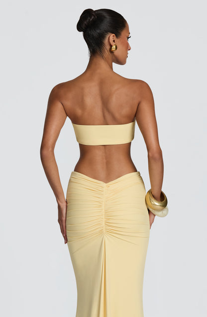 Top de bikini bandeau amarillo limón con espalda lisa y adorno dorado frontal al centro