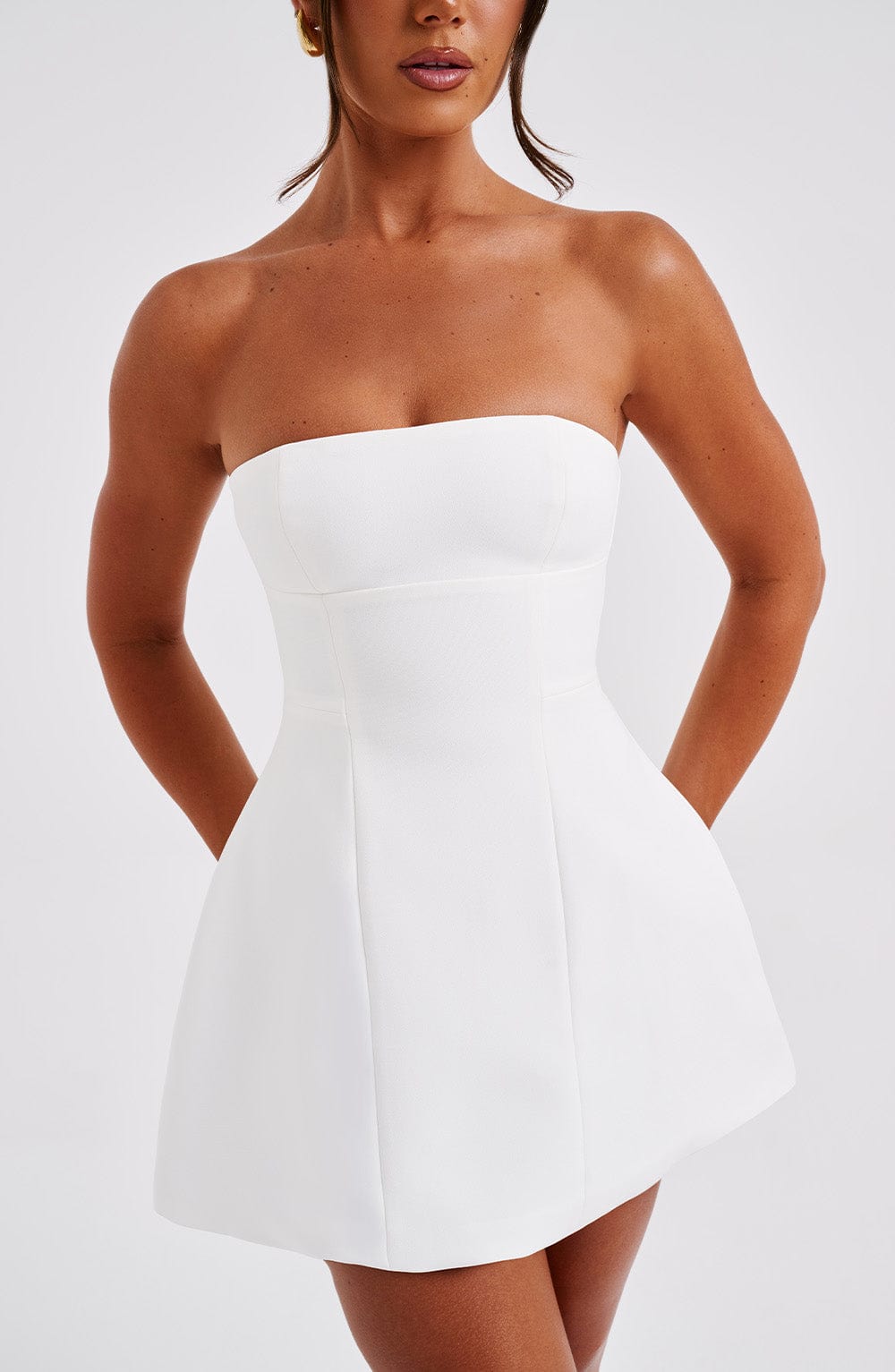 Vestido blanco strapless entallado con falda acampanada, vista frontal cercana.