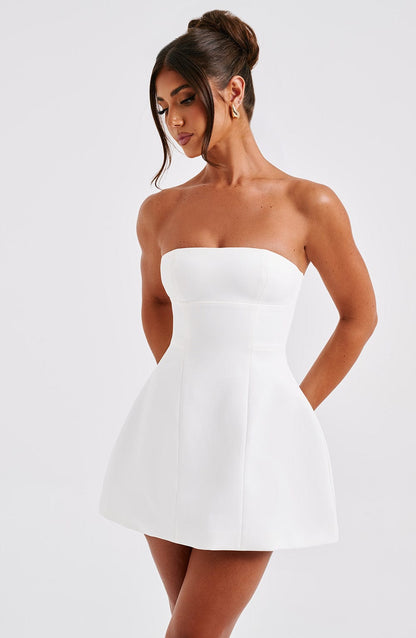 Vestido blanco strapless con falda acampanada y costuras, vista 3/4 lateral.