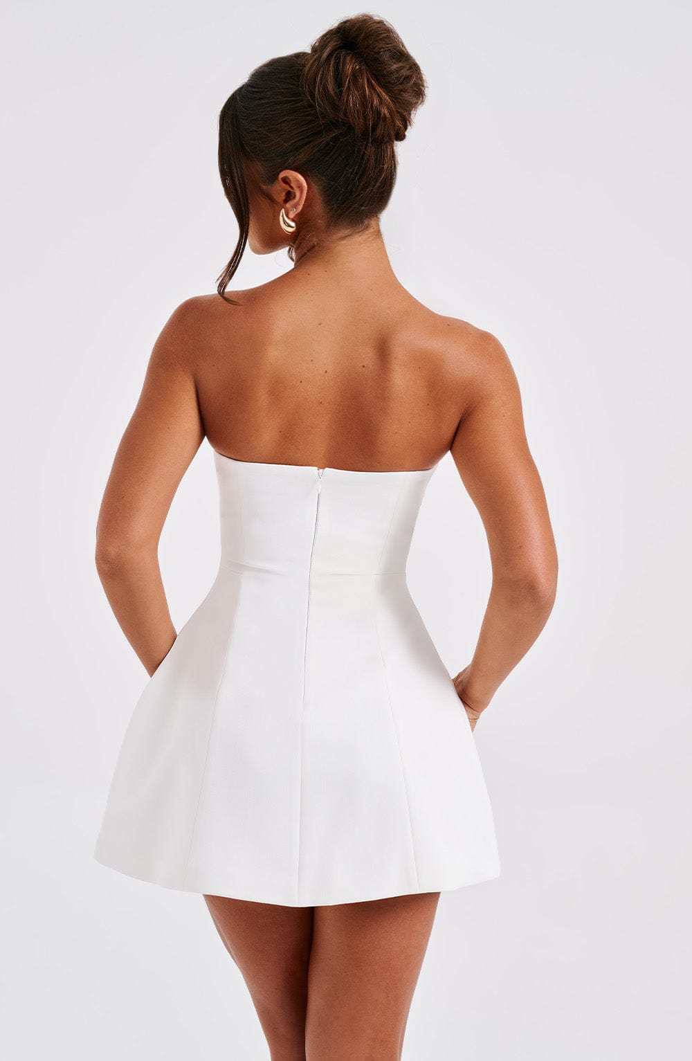 Vestido blanco strapless, vista trasera, con abertura en la espalda y costuras.