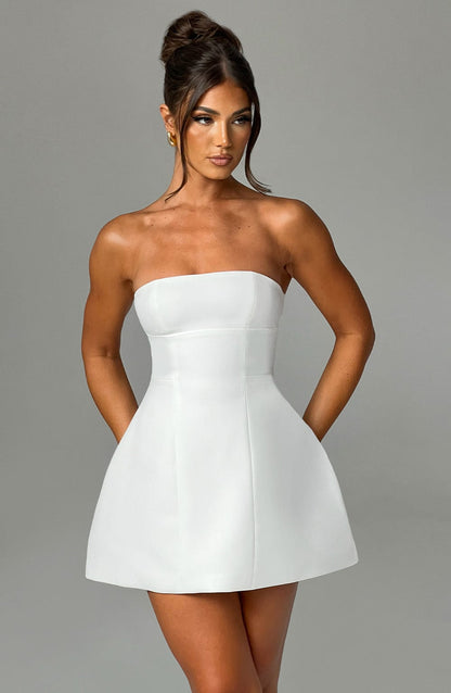 Vestido blanco strapless con falda acampanada y escote recto, vista frontal.