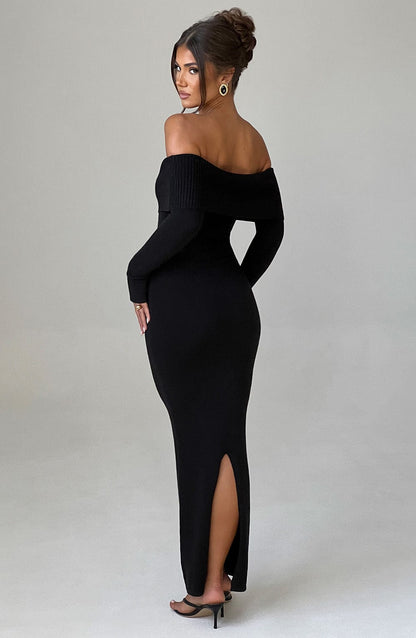 Vestido negro ajustado con escote bardot y abertura en la pierna, vista lateral