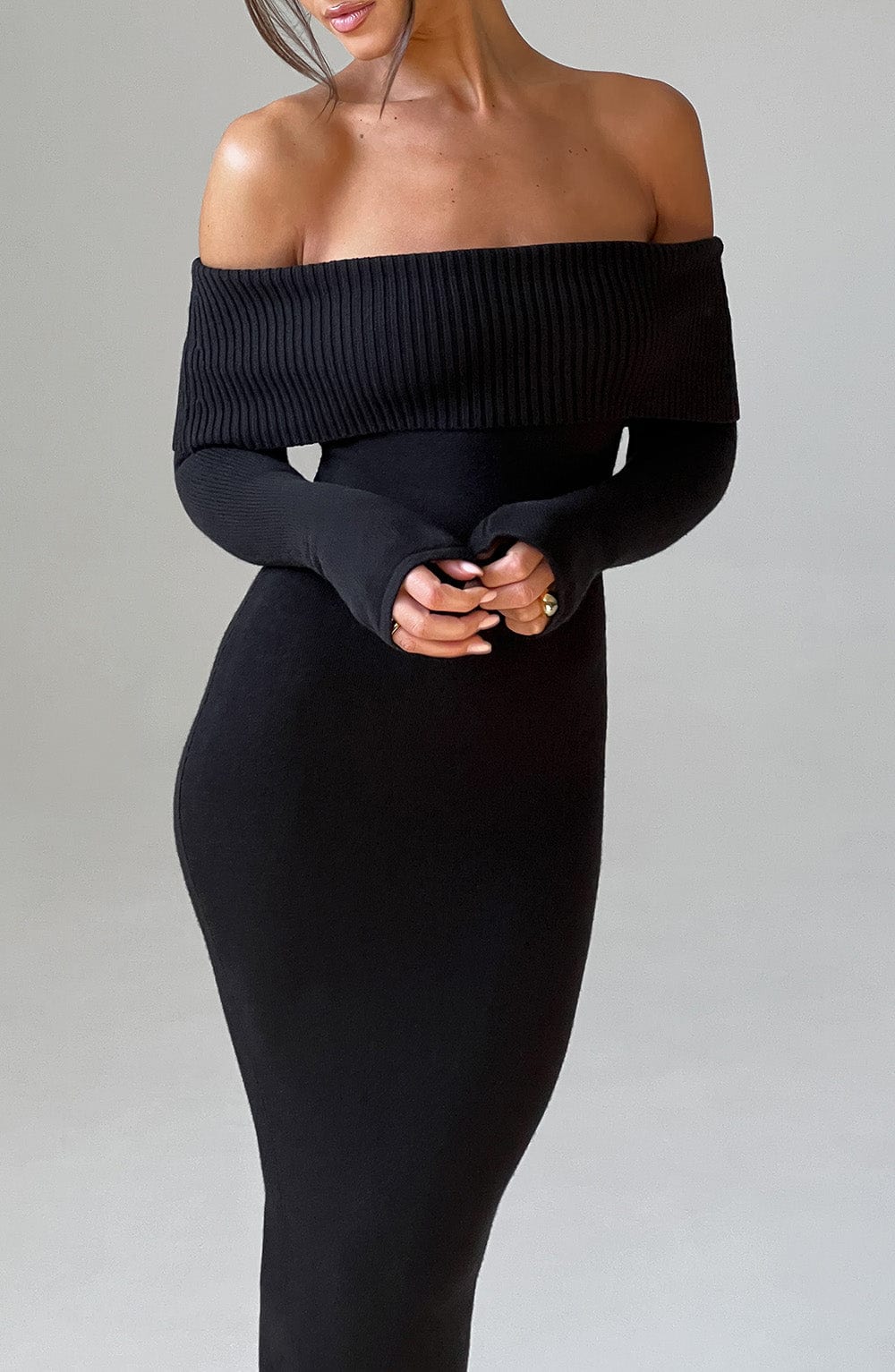 Vestido negro ajustado con hombros descubiertos y manga larga, vista desde arriba