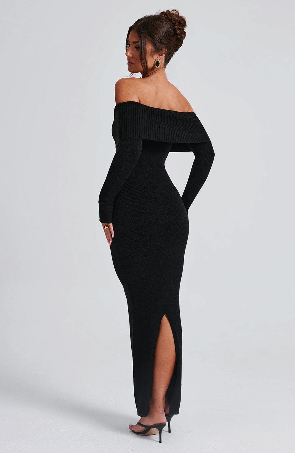 Vestido negro con escote bardot y mangas largas, abertura en la pierna, vista lateral