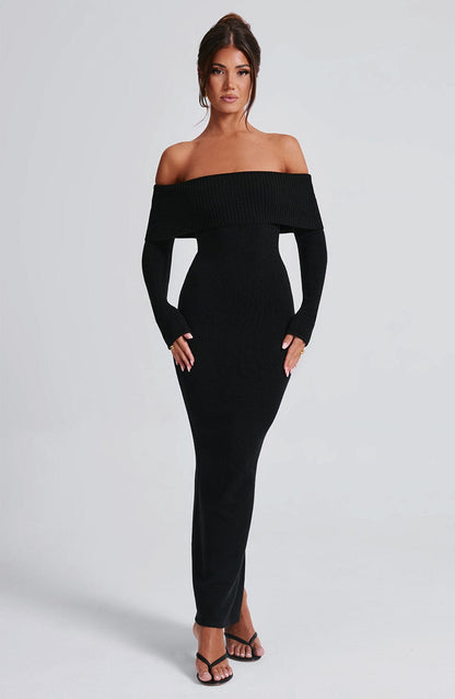 Vestido negro ajustado con hombros descubiertos y abertura frontal, vista tres cuartos