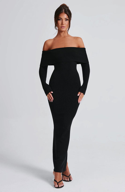 Vestido negro ajustado con hombros descubiertos y abertura frontal, vista tres cuartos