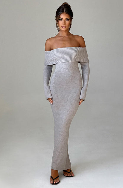 Vestido largo de punto gris claro, hombros descubiertos y manga larga caída, ajustado.