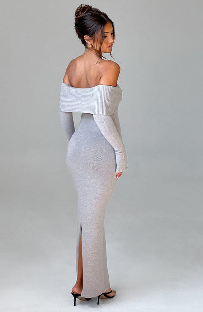 Vestido largo de punto gris claro con escote off-shoulder y abertura frontal en la pierna.