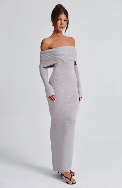 Vestido largo de punto gris claro con escote off-shoulder y falda ajustada hasta el suelo.