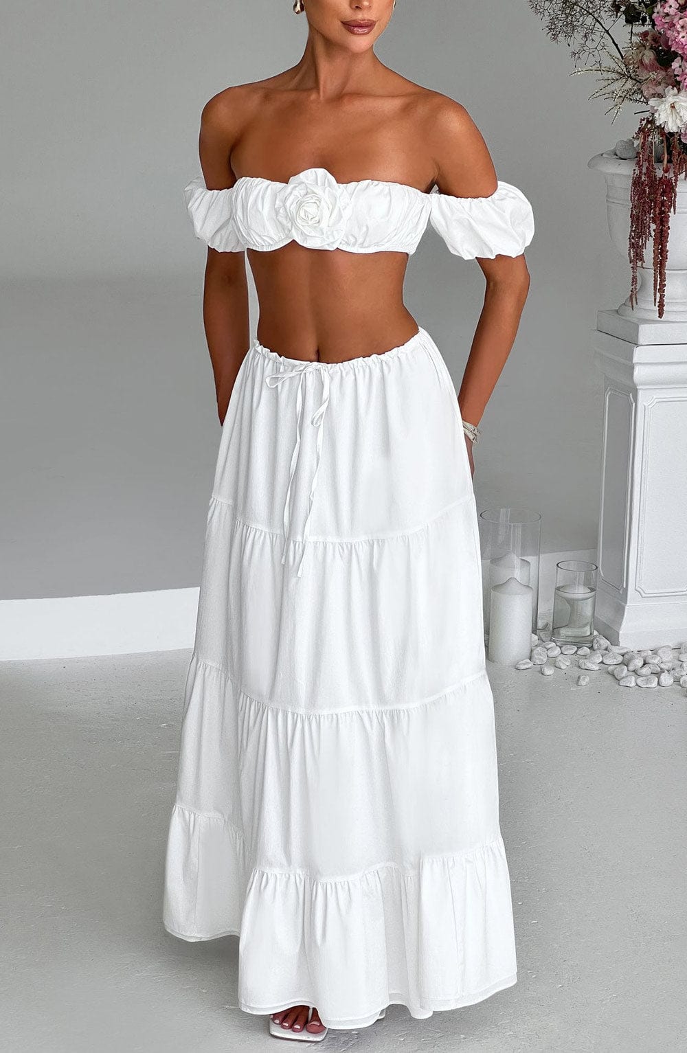 Top marfil con escote bardot y volante abullonado, flor central en relieve