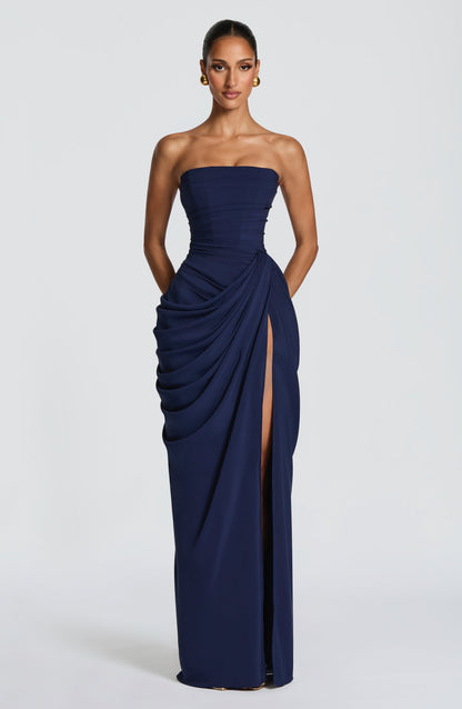 Vestido largo azul oscuro strapless con drapeado lateral, textura fruncida y abertura larga.