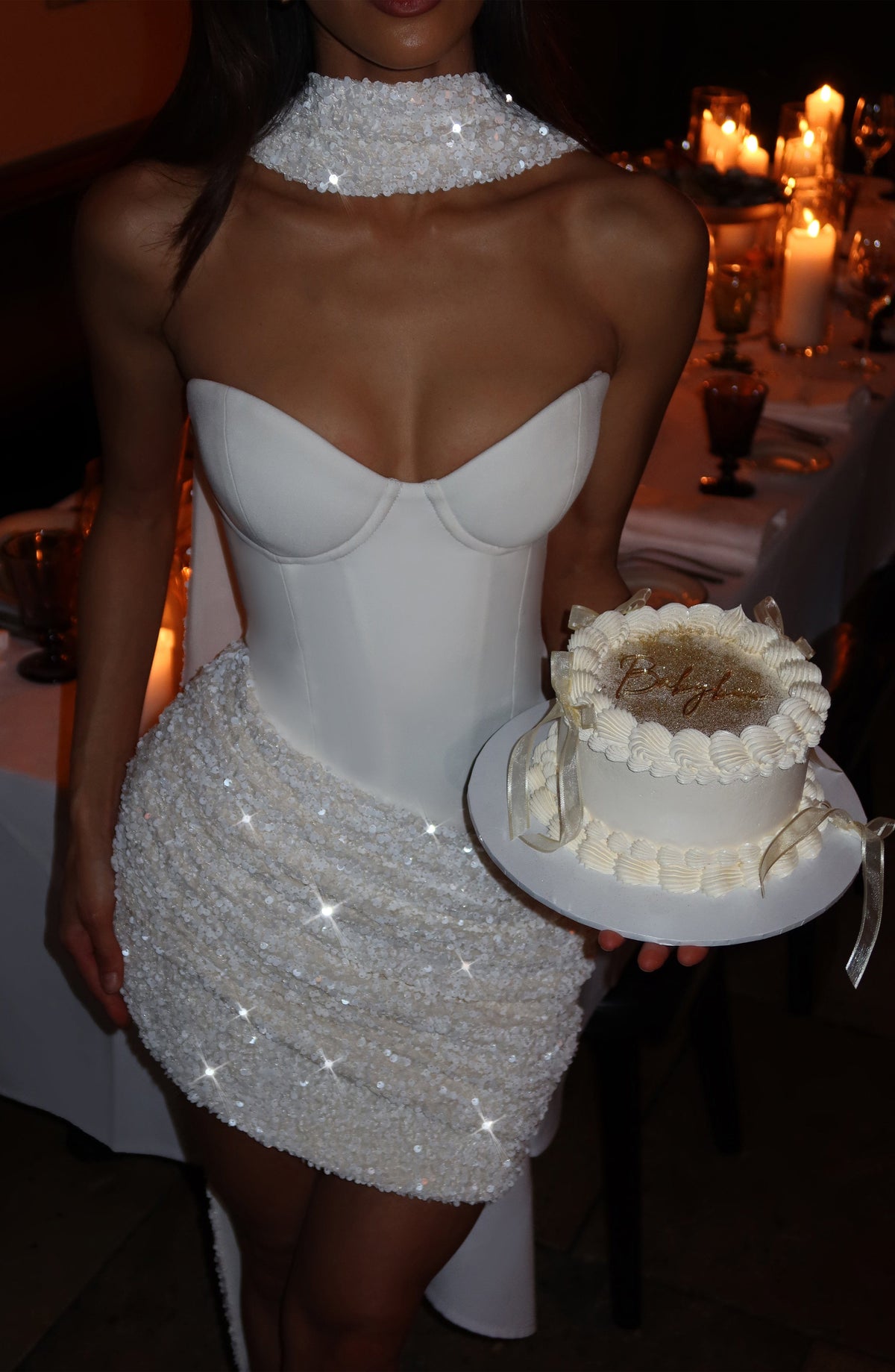 Vestido blanco sin mangas con escote corazón y acabado brillante con falda corta.