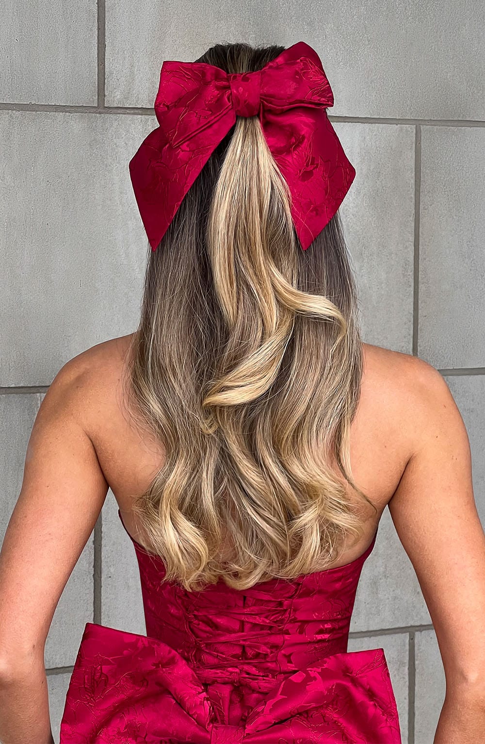 Lazo de cabello rojo tipo moño grande con textura, sujetado al pelo