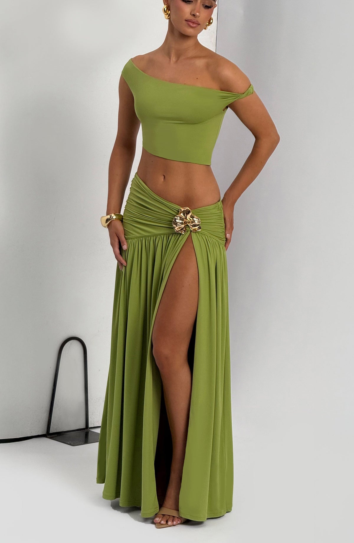 Conjunto verde oliva con top off-shoulder y falda larga con abertura y broche decorativo