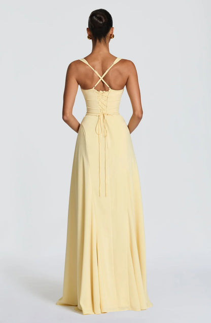 Vestido IRIS amarillo claro con espalda cruzada, lazo en la cintura y falda larga