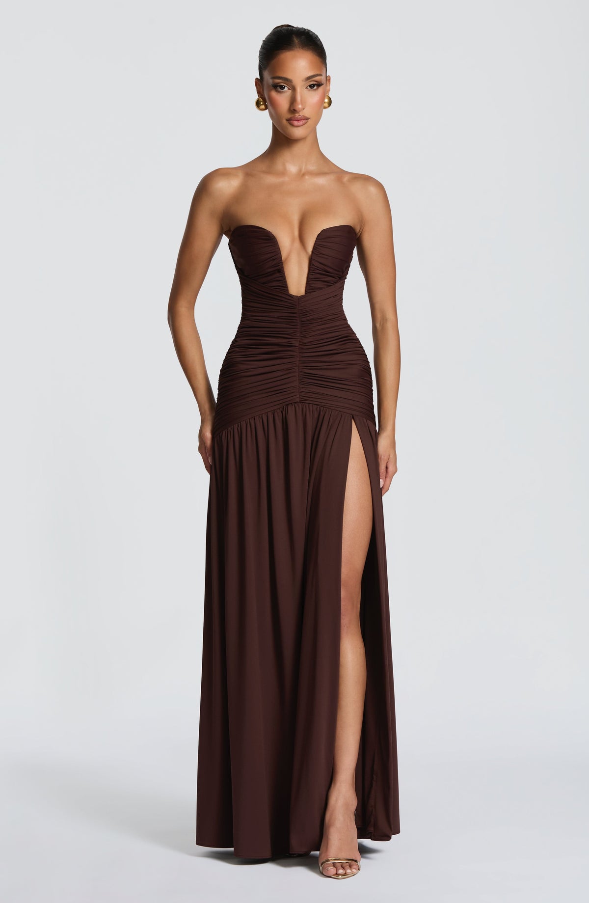 Vestido largo sin tirantes color oscuro con fruncido vertical y abertura en la falda