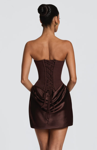 Vestido corto satinado marrón oscuro con espalda cruzada y cordones tipo corsé.