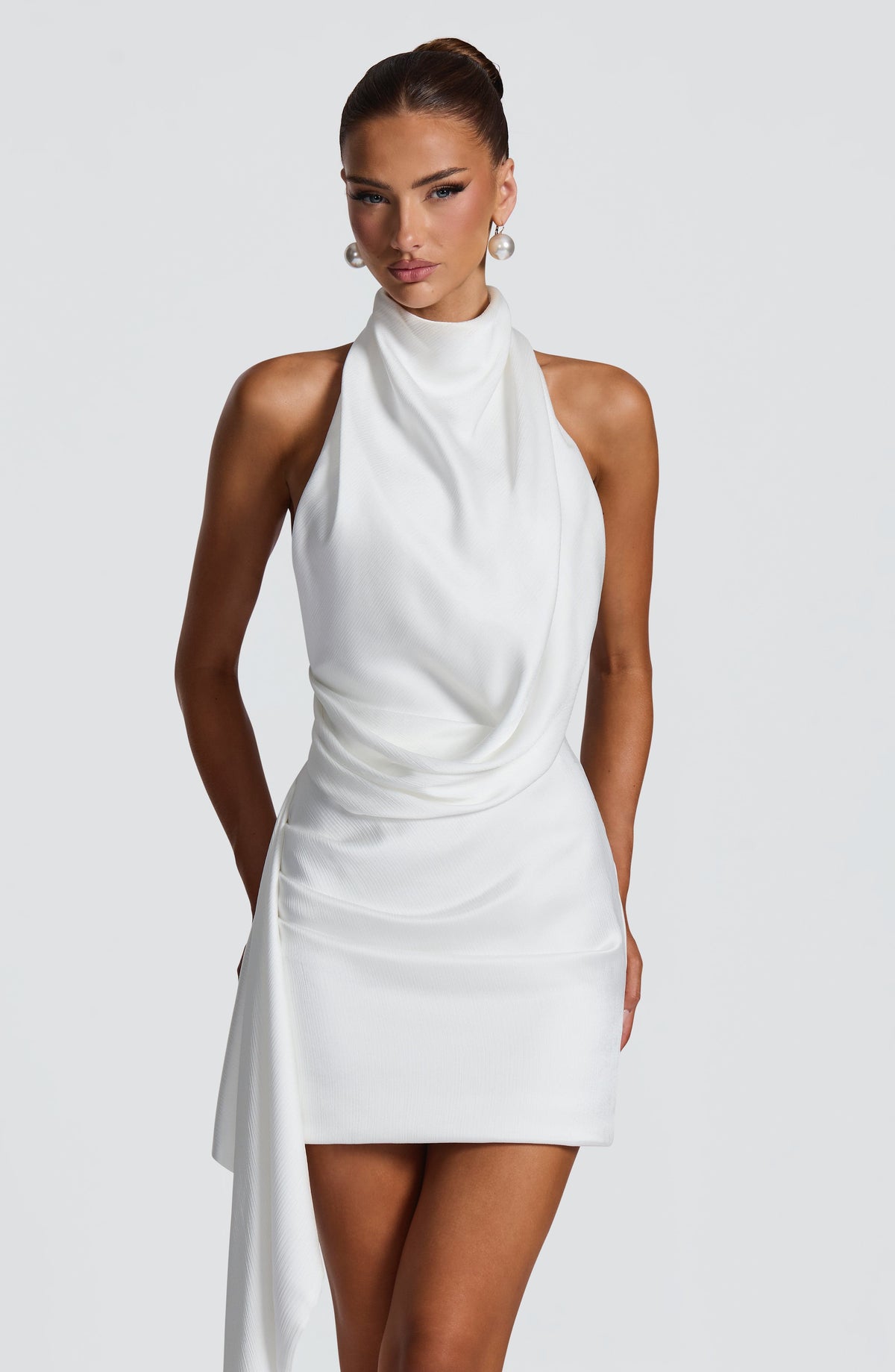 Vestido corto blanco marfil sin mangas, cuello alto y drapeado frontal