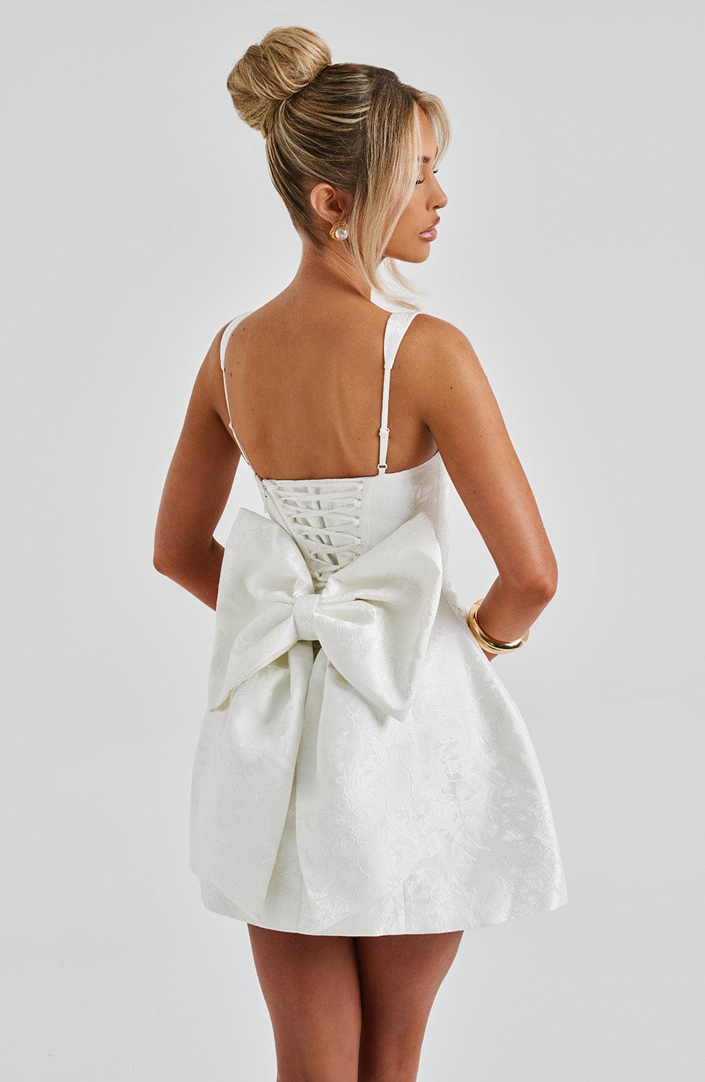 Vestido blanco con espalda descubierta y lazo grande en la zona media, tirantes finos