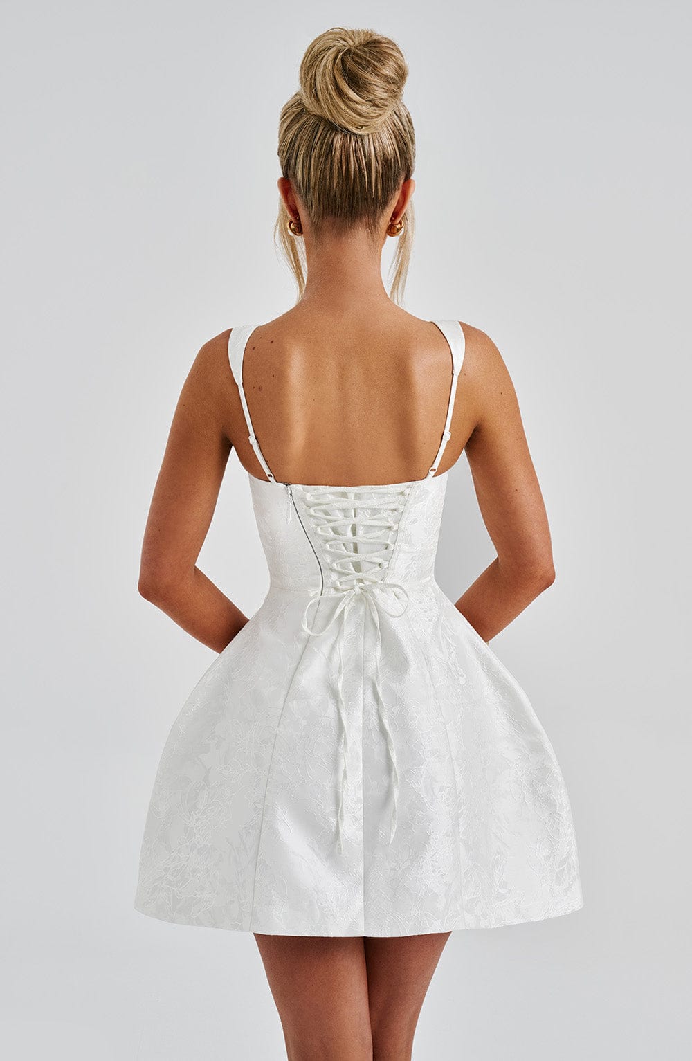 Vestido blanco corto con tirantes finos y corsé trasero con cordones al centro
