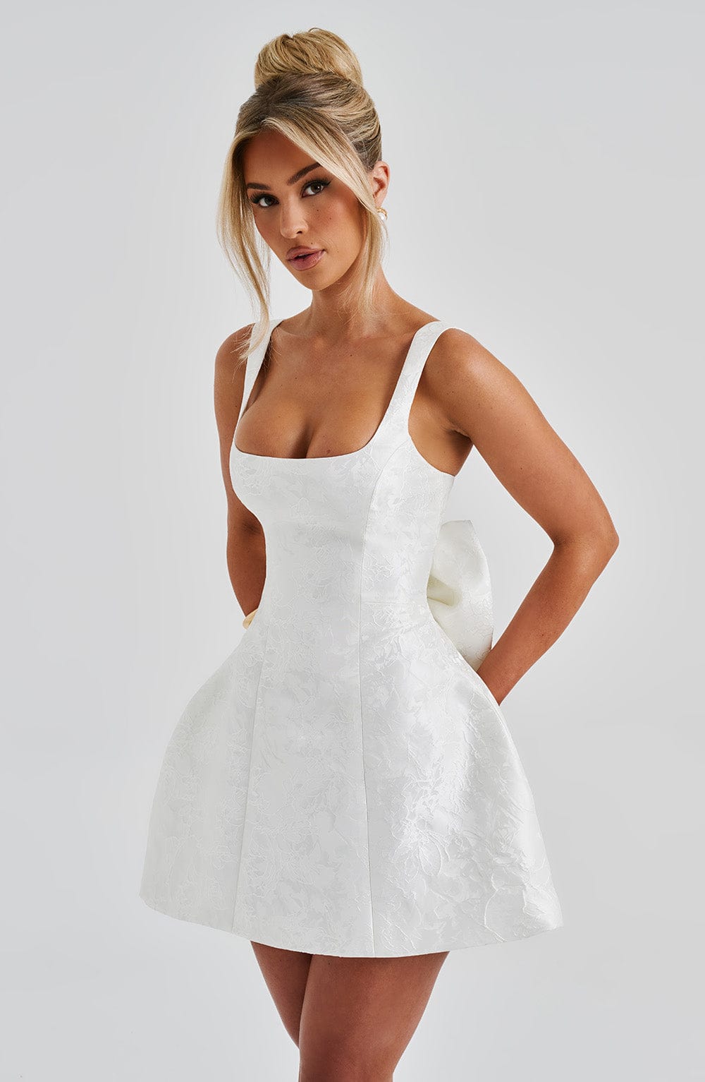 Vestido blanco corto entallado con tirantes finos y falda acampanada de textura