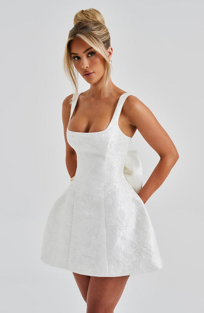 Vestido blanco corto entallado con tirantes finos y falda acampanada de textura