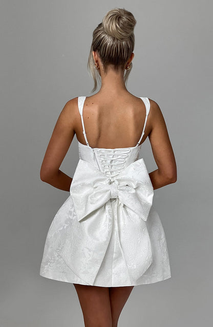 Vestido blanco con tirantes finos en la espalda y gran lazo en el centro trasero