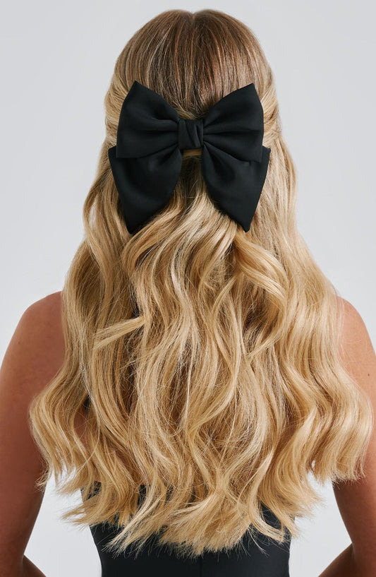 Lazo para el pelo negro con nudo grande, sobre cabello rubio ondulado
