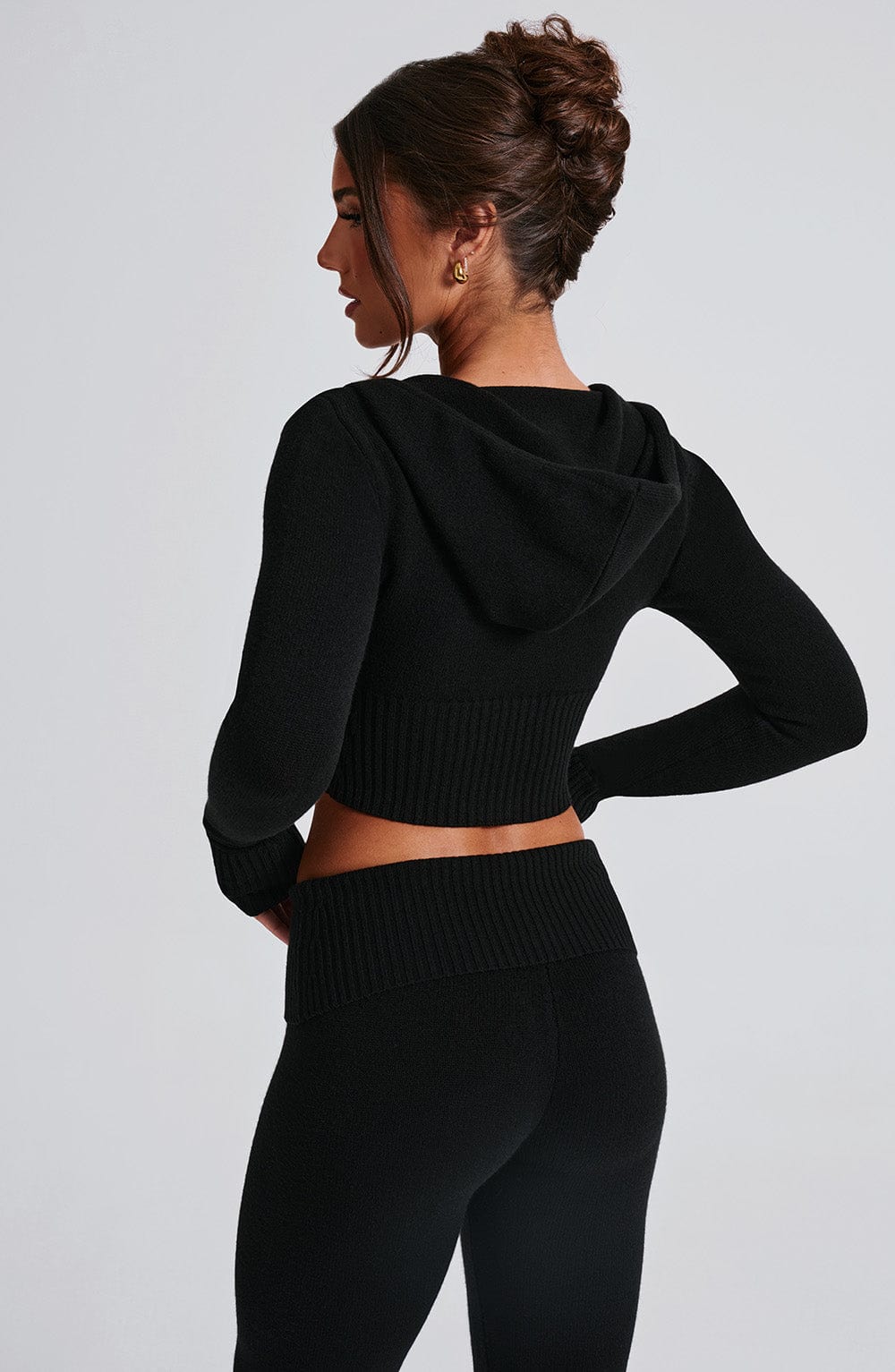 Sudadera negra corta de punto con capucha, vista trasera lateral