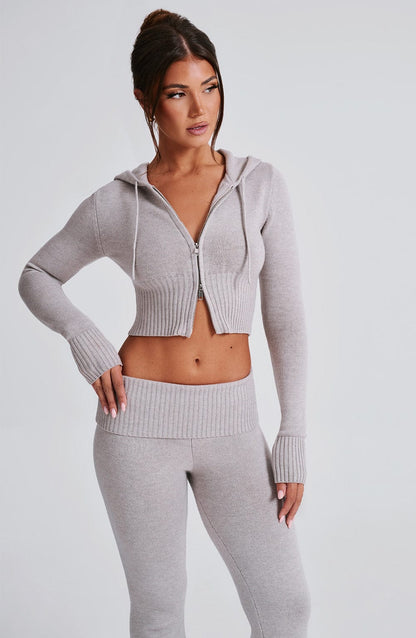 Conjunto de sudadera con cremallera y capucha gris claro; pantalón a juego.