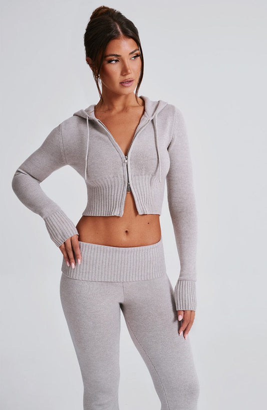Conjunto de sudadera con cremallera y capucha gris claro; pantalón a juego.