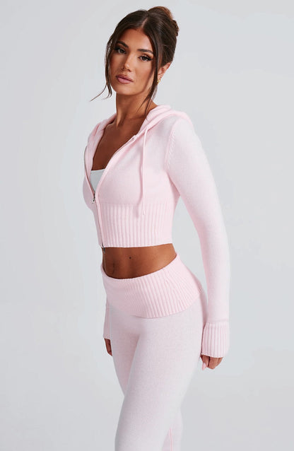 Sudadera rosa con capucha y cremallera frontal; pantalón de punto a juego