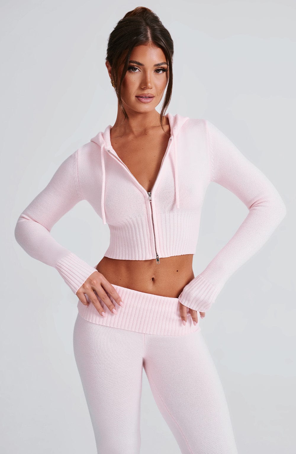 Conjunto de sudadera rosa con capucha y cierre, y pantalón de punto a juego