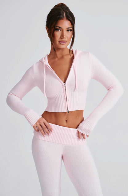 Conjunto de sudadera rosa con capucha y cierre, y pantalón de punto a juego
