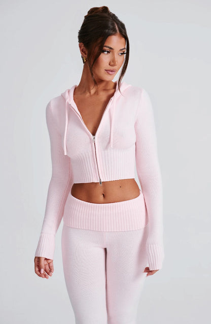 Sudadera rosa con capucha y cremallera; detalle del bajo y pantalón de punto