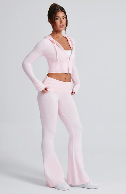 Sudadera rosa con capucha y cierre frontal; pantalón de punto y cintura elástica