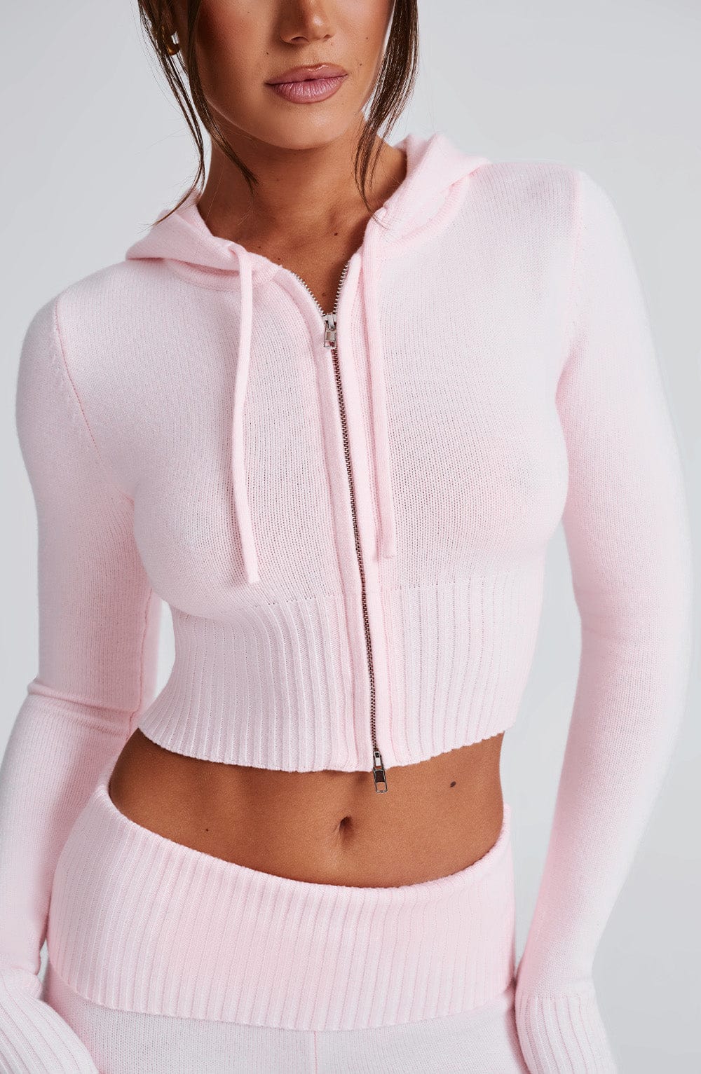 Sudadera rosa de punto acanalado con capucha, cremallera frontal y cordones en la capucha
