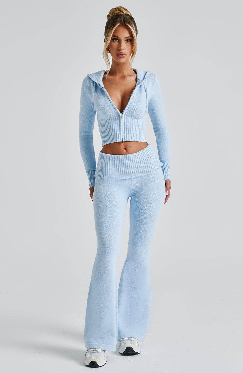Pantalón de punto azul celeste acampanado, pierna amplia y costuras verticales