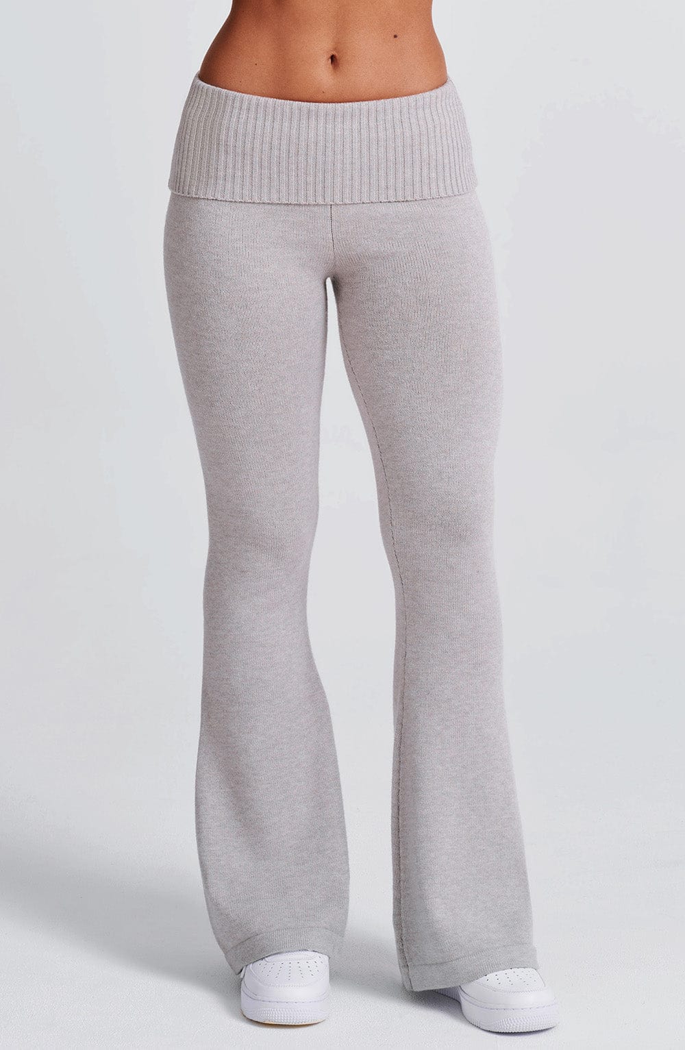 Pantalón de punto gris claro acampanado, costura frontal y elástico en la cintura.