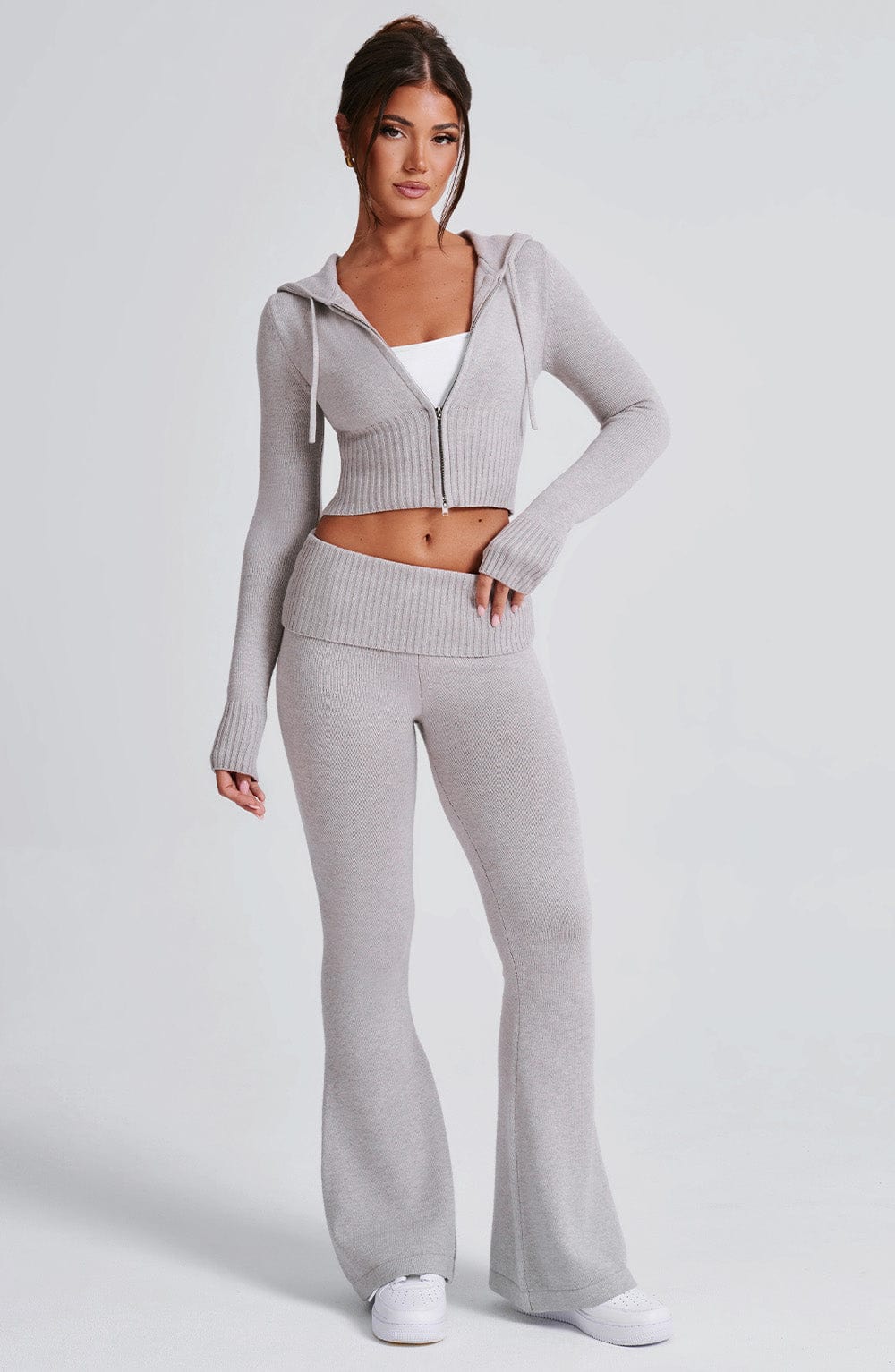Pantalón acampanado de punto gris claro con tiro medio, cintura elástica y piernas largas.