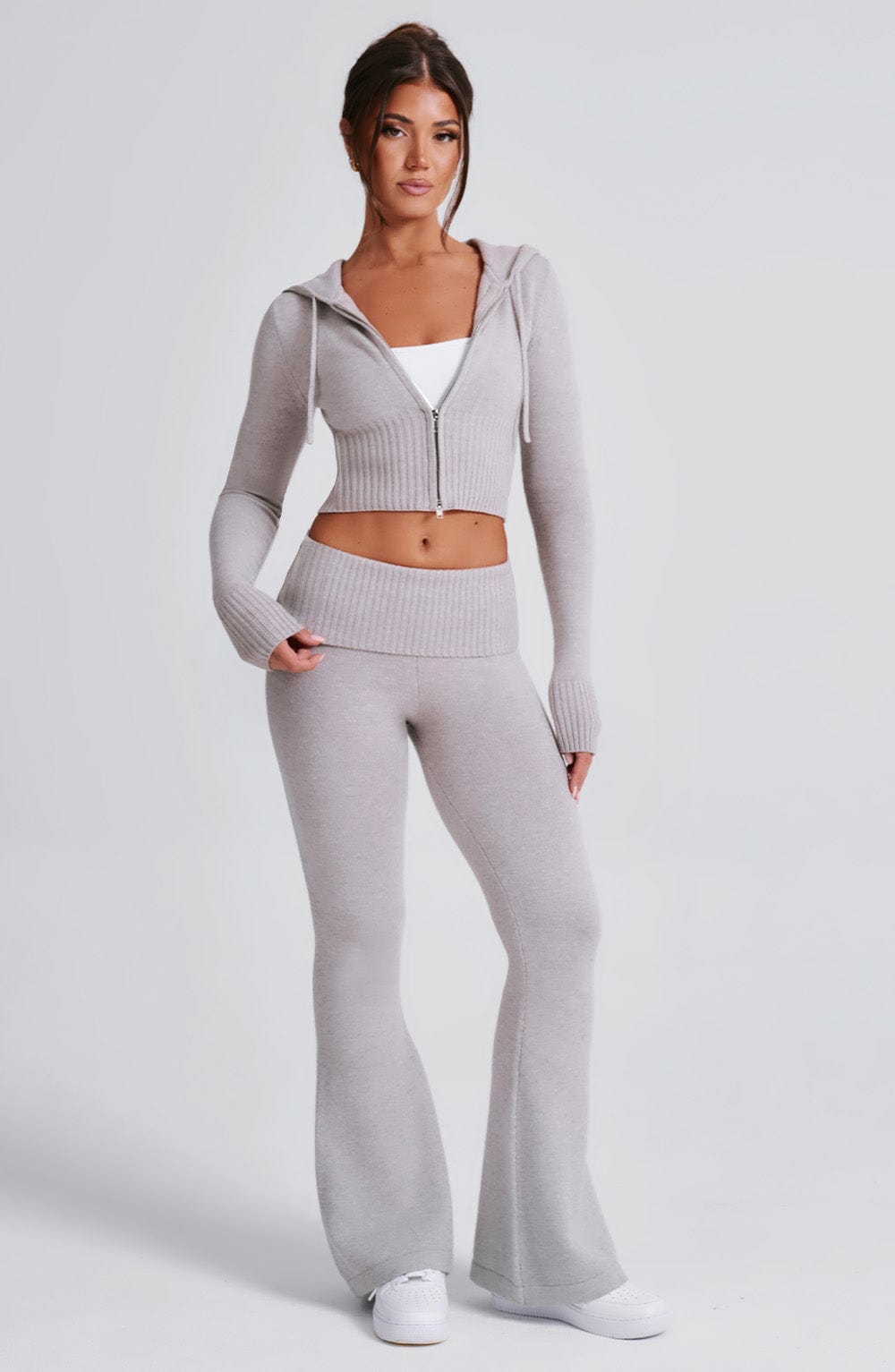 Pantalón de punto gris claro acampanado, cintura elástica ancha y bajo amplio.