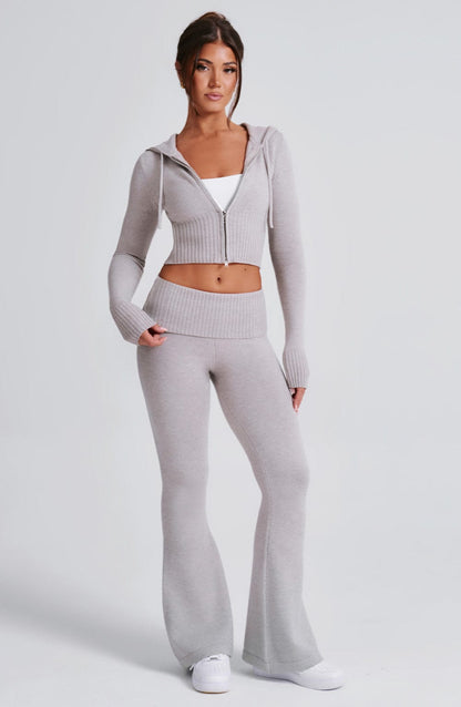 Pantalón de punto gris claro acampanado, cintura elástica ancha y bajo amplio.