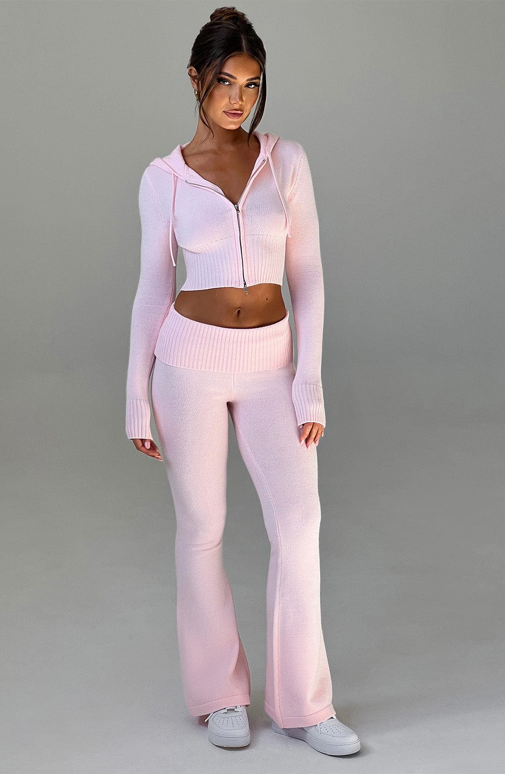 Pantalón rosa claro de punto acanalado con cintura elástica y pierna acampanada.