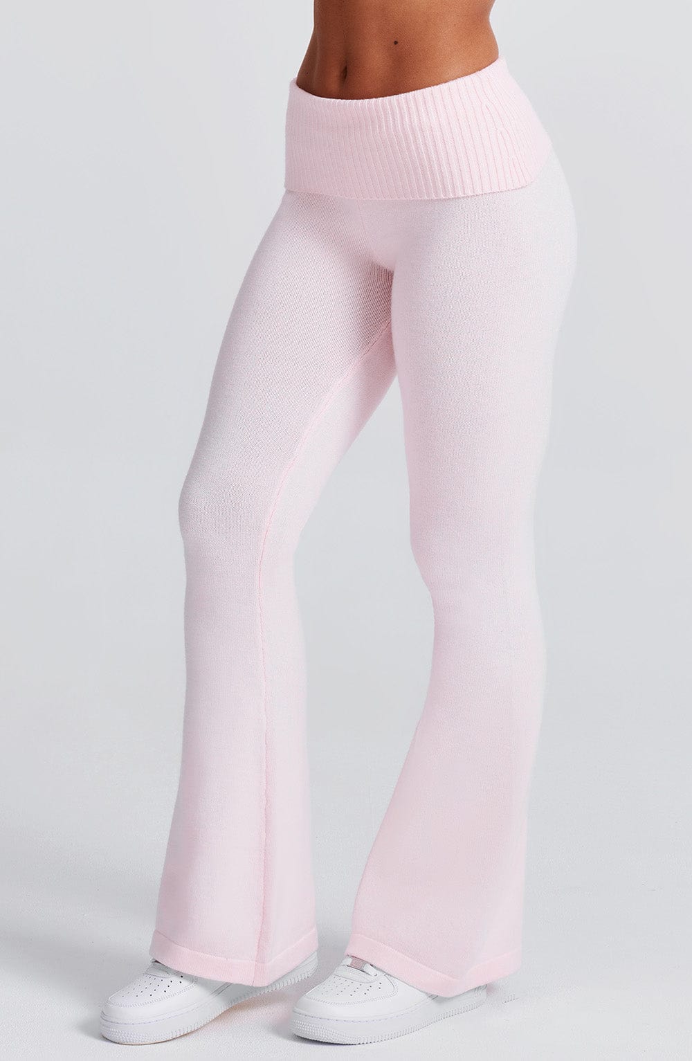 Pantalón rosa claro de punto acanalado, pierna recta y corte acampanado en el bajo.