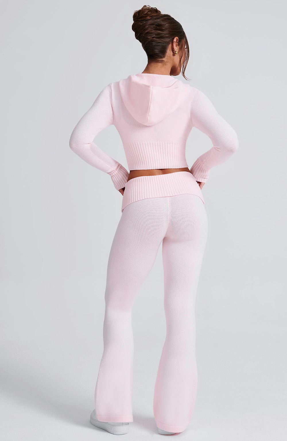 Pantalón rosa claro de punto acanalado con cintura elástica y pierna amplia acampanada.
