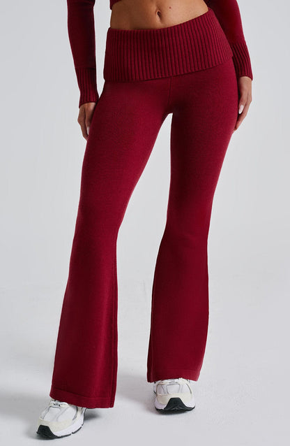 Pantalón rojo acampanado de punto con detalle de canalé en la cintura.