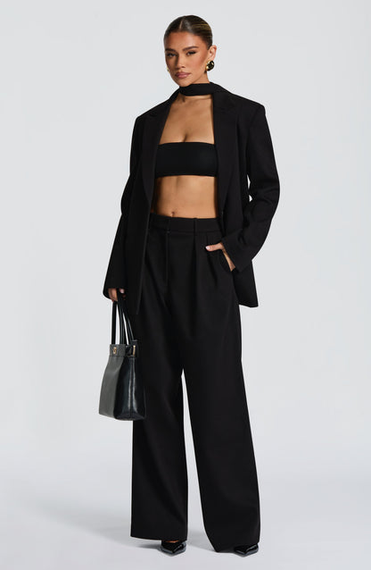 Top bandeau negro sin tirantes, con dobladillo elástico y corte corto.