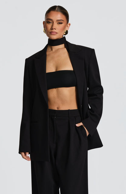 Top negro bandeau sin tirantes, con escote cuadrado y ajuste entallado.